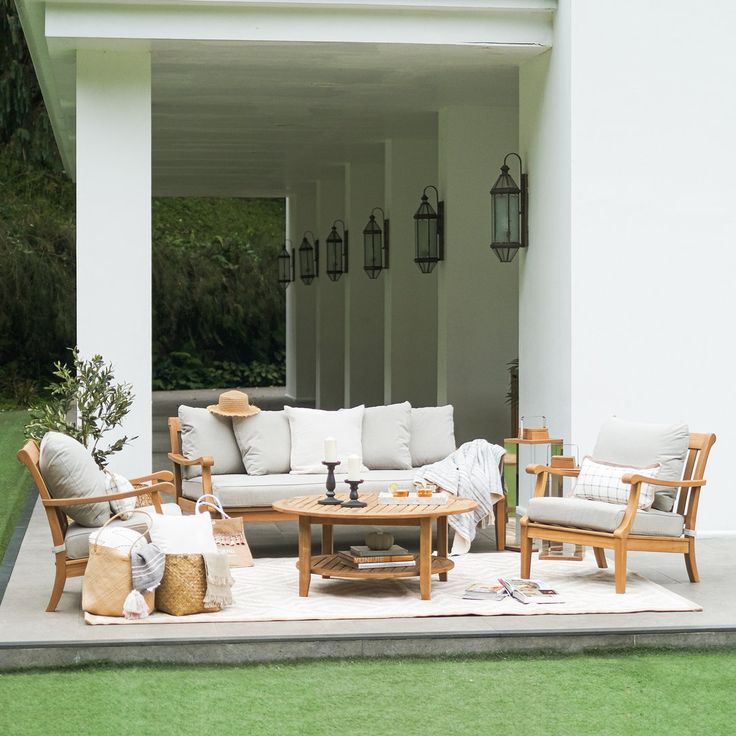 an outdoor living room with white furniture and green grass