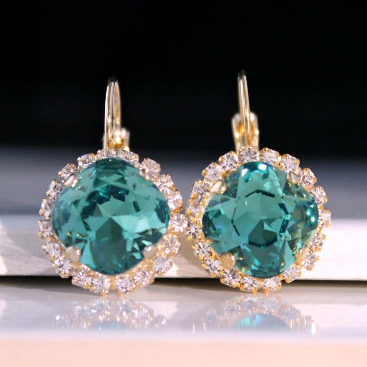 Sparkly, eye-catching, green crystal earrings will brighten up any outfit! Precision-cut crystals and unmatched, gorgeous colors are always show-stoppers! Details: * Premium European Crystals in Setting- 3/4"(18mm) * 14k Gold-Plated Lever Back Earrings * Earring Length- 1"(25mm) * Nickel and Lead-free These earrings come in a jewelry bag and box with ribbon. Turquoise Earrings Gold, Elegant Gold Necklace, Emerald Earrings Drop, Crystal Teardrop Earrings, Emerald Green Earrings, Box With Ribbon, Diamond Cluster Earrings, Bling Earrings, Bridesmaid Gifts Jewelry