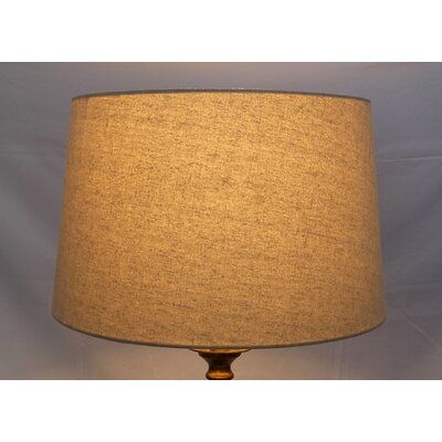 a lamp that is on top of a white wall with a brown shade over it