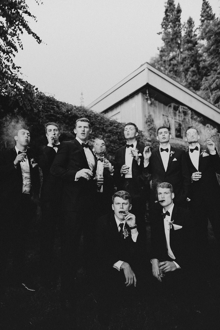 a group of men in tuxedos posing for a photo