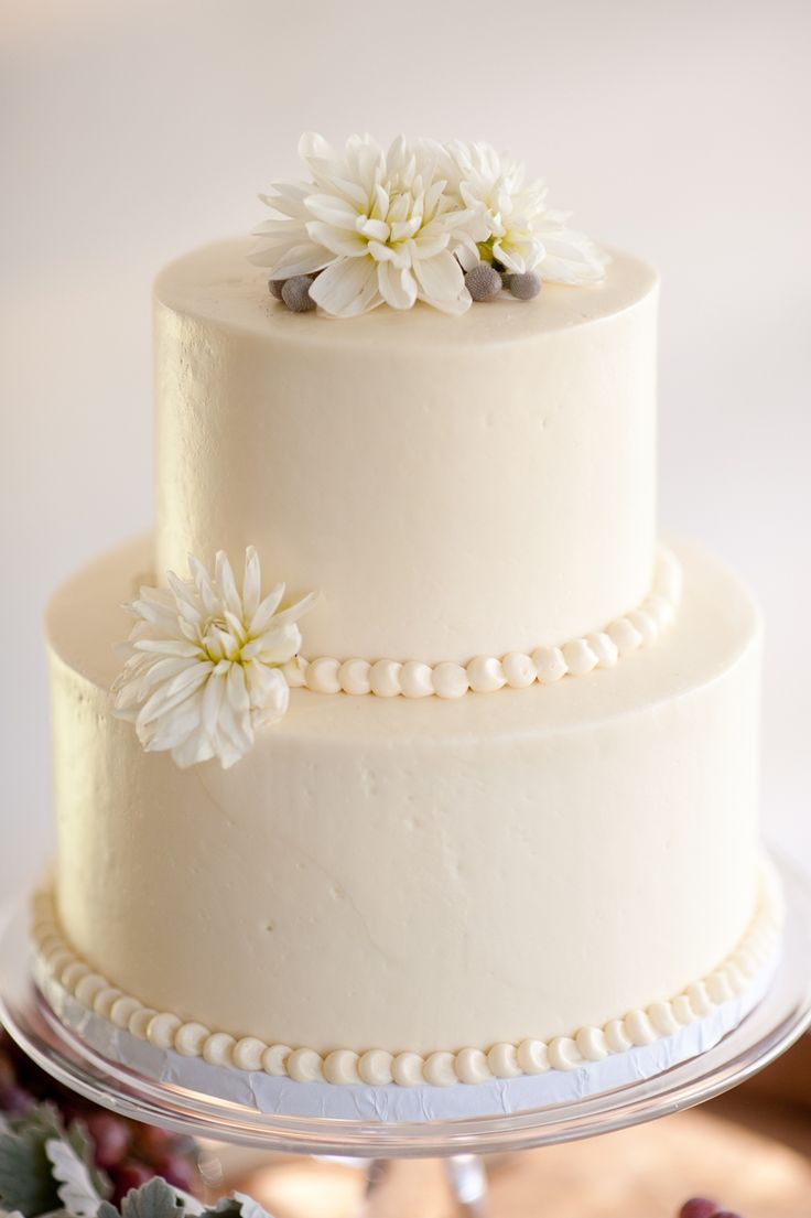 a three tiered cake with white flowers on top