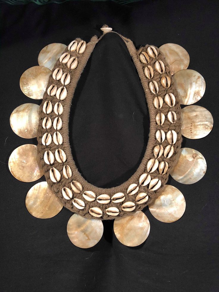 Ceremonial tribal necklace, traditional necklace from Papua. Object of collection in shells and vegetable fiber. DIMENSIONS: Length / Lenght: 32 cm (12.5'' inches) Width / Width: 30 cm (12'' inches) Weight / Weight: 198 g. Superb work of art unique in the world. To be framed or to wear on special occasions because these necklaces are worthy of a museum. For any question or precision please write to the MaoArtCollection shop on this page. Looking forward to serving you! Handmade Necklaces For Ceremonial Festivals, Handmade Ceremonial Necklaces For Festivals, Handmade Ceremonial Necklace For Festivals, Bohemian Brown Ceremonial Jewelry, Artisan Necklace For Ceremonial Festivals, Traditional Handmade Necklaces For Festival, Handmade Traditional Necklace For Festivals, Traditional Handwoven Necklaces For Festivals, Traditional Handwoven Necklace For Festivals