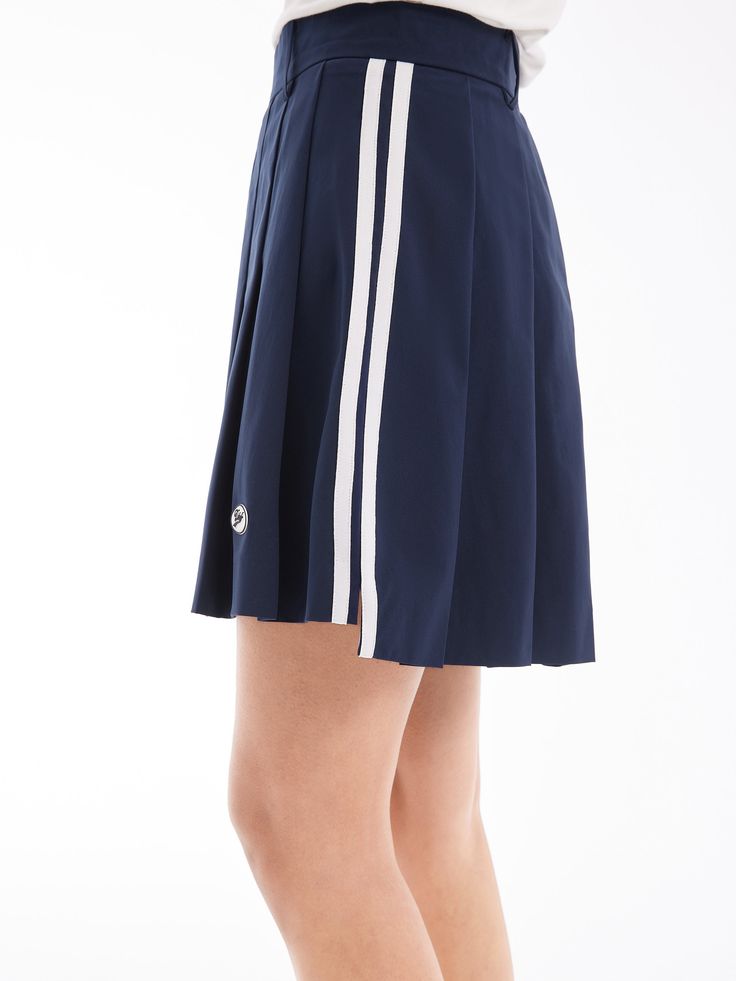 Details: Girly Pleated Skirt In NavyBuilt-in shorts for a discreet summer lookStriped webbing at the side for a vintage college look. Materials & Care: Fabric: Polyester 100%.Lining: nylon 92.4 %Spandex 7.6 % Hand wash | Dry clean Do not bleach Size & Fit: Model is 5'7", Bust 32, Waist 24, Hips 35, wearing a size S Item #: SN2SK10 Casual Navy Tennis Skirt For Spring, Casual Knee-length Tennis Skirt For Summer, Casual Knee-length Summer Tennis Skirt, Navy Sporty Skort For Summer, Navy Casual Tennis Skirt, Casual Navy Pleated Skort, Navy Casual Pleated Skirt Skort, Preppy Mini Skirt For Summer, Navy Casual Pleated Skort