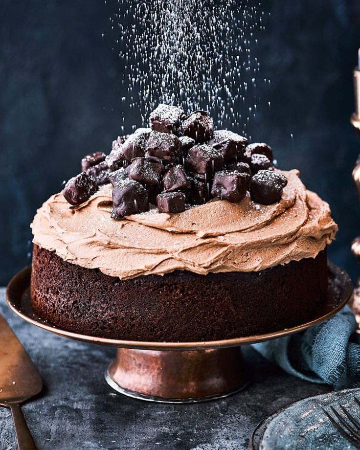 a cake with chocolate frosting and sprinkles is on a metal platter