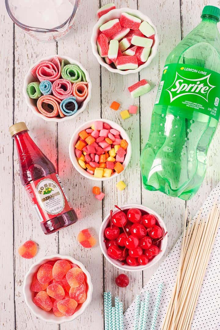 the ingredients to make this candy bar are displayed in small bowls on a white wooden table