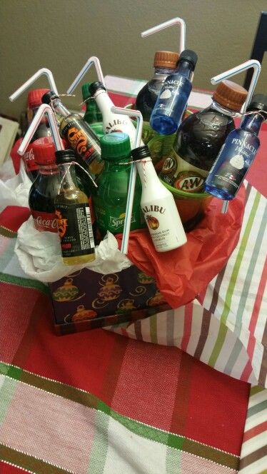 a basket filled with lots of bottles on top of a red and white checkered table cloth