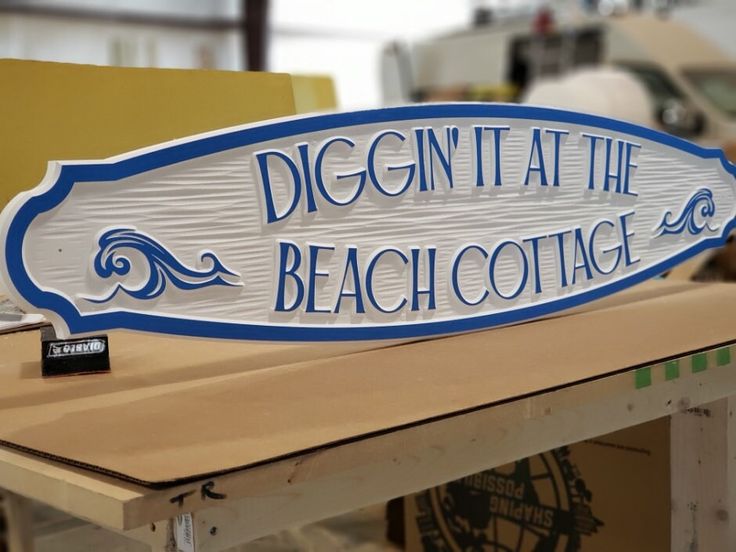 a sign that says digign at the beach cottage sitting on top of a table