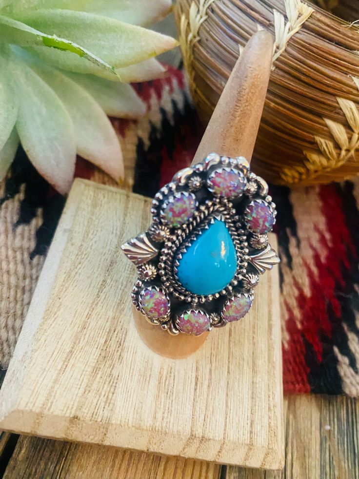 New without tags JEWELRY TYPE : Ring METAL : Sterling Silver MAIN STONE : Opal and Turquoise This is a gorgeous handmade Turquoise, Pink Opal and Sterling Silver Adjustable Cluster Ring. Ring measures 1 3/4 inches long and 1 1/2 inches wide. Stamped sterling and Nizhoni. So beautiful! **Non-Native** Thank you for checking out our store. Please let us know if you have any questions. 4/4/23 Turquoise Multi-stone Ring For Gift, Unique Turquoise Multi-stone Opal Ring, Unique Turquoise Opal Ring With Multi-stone Design, Artisan Multi-stone Turquoise Ring, Artisan Turquoise Ring Jewelry, Southwestern Turquoise Opal Ring Gift, Southwestern Style Turquoise Opal Ring As Gift, Southwestern Style Turquoise Opal Ring Gift, Turquoise Oval Multi-stone Opal Ring