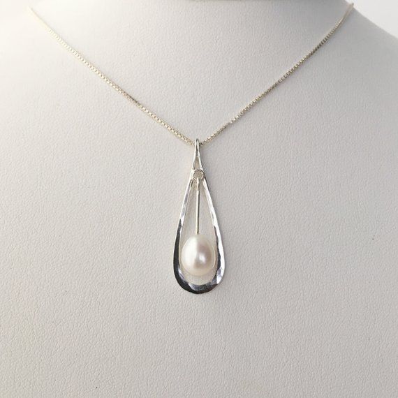 This hammered sterling silver pendant is just under 1 1/2" long and 1/2" wide. It features a teardrop shaped Pearl that is a little over 1/4" long. The pendant is on a .85 mm sterling silver box chain. The simple drop shape is elegant and beautiful.The necklace will be shipped in a decorative cardboard jewelry box filled with an anti tarnish cotton. Sterling silver is a metal that can tarnish, storing it in the box in which it is shipped will help prevent tarnishing. The piece can be cleaned wit Silver Teardrop Pearl Pendant Jewelry, Teardrop Pearl Pendant In Sterling Silver, Elegant Teardrop Drop Necklace Nickel Free, Sterling Silver Teardrop Pearl Pendant Jewelry, Elegant Teardrop Nickel Free Drop Necklace, Elegant Teardrop Nickel-free Drop Necklace, Nickel Free Silver Teardrop Drop Necklace, Sterling Silver Teardrop Pearl Pendant, Nickel-free Silver Teardrop Drop Necklace