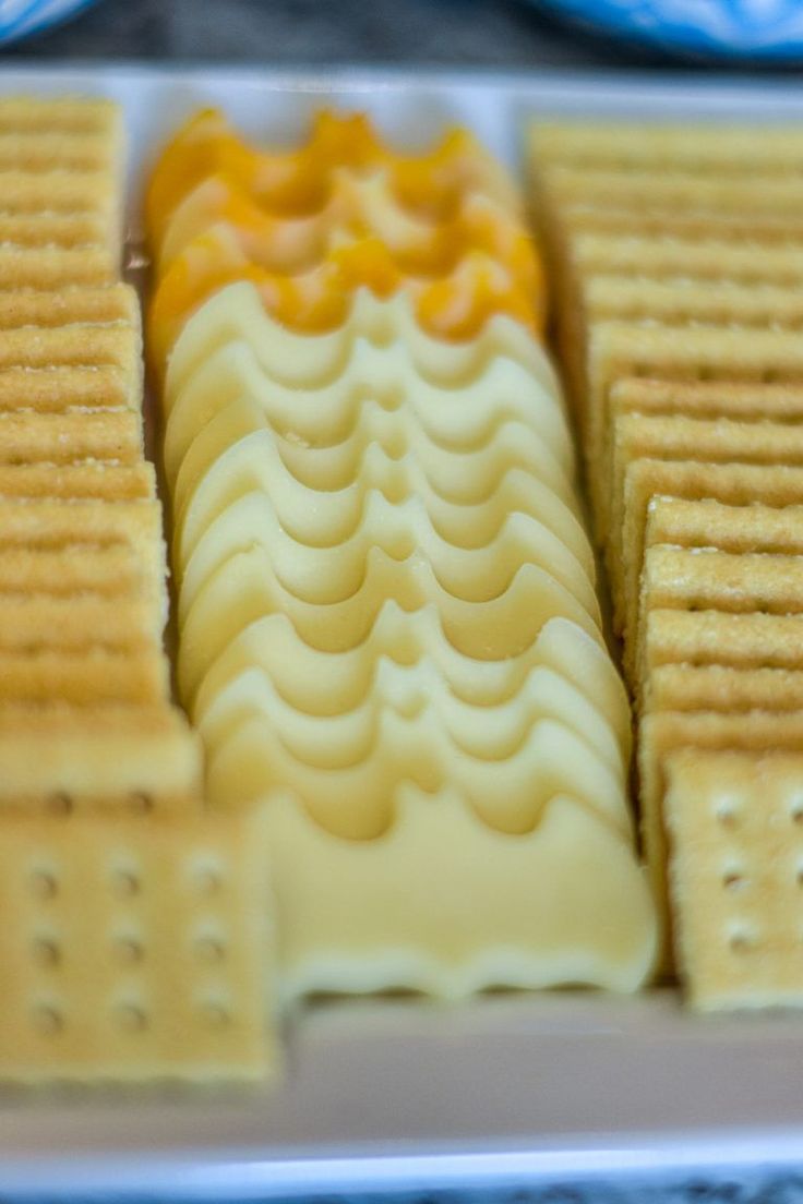 crackers are arranged on a plate with cheese