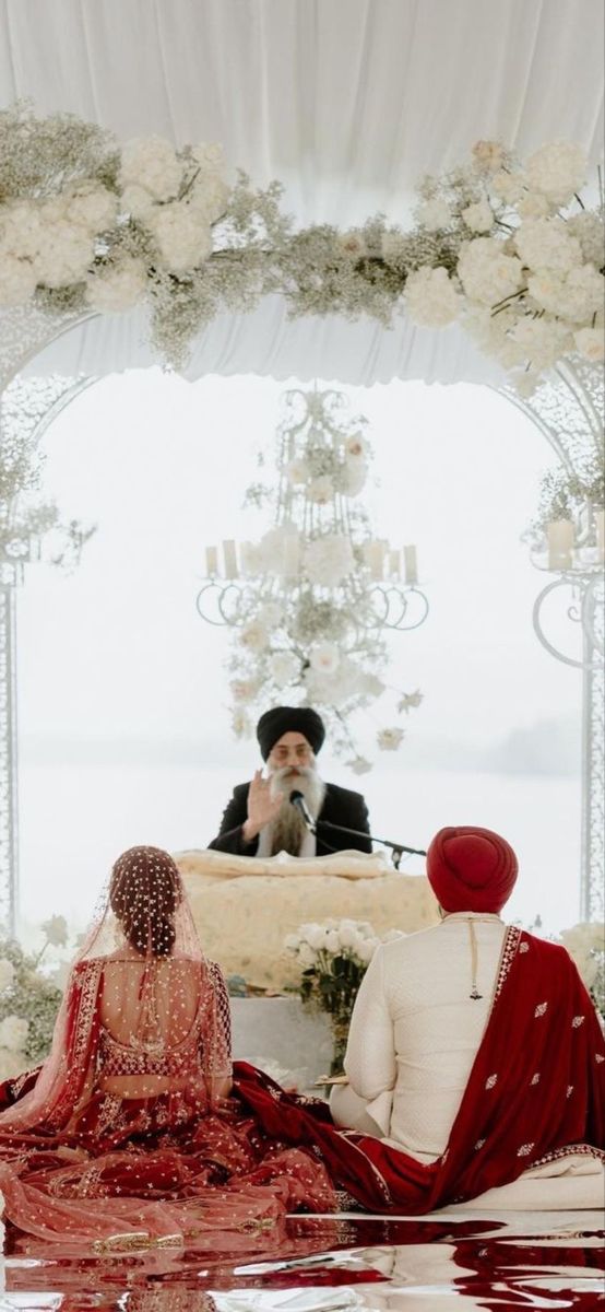 the bride and groom are sitting down for their wedding ceremony