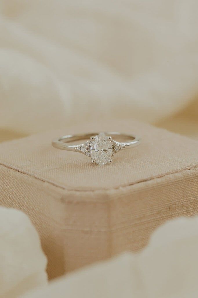 a diamond ring sitting on top of a pillow