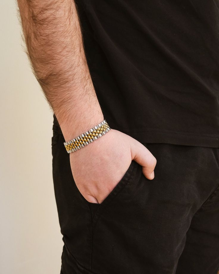 This sleek and sophisticated watch band chain bracelet is the perfect statement piece for any gentleman. Elevate your style with this luxurious men's jewelry that combines fashion and function. Make a bold statement with this exclusive accessory. Materials: 14K gold plated stainless steel, rhodium plated stainless steel Features: Measures 7" length, 0.6" width, Lead & Nickel free, foldover single channel clasp Elegant Cuban Link Bracelet With Stainless Steel Clasp, Gold Cuban Link Bracelet In Modern Style, Gold Cuban Link Bracelet With Modern Style, Modern Gold Cuban Link Bracelet With Box Chain, Modern Stainless Steel Bracelet With Gold Chain, Gold Stainless Steel Jubilee Chain Link Bracelet, Stainless Steel Gold Jubilee Chain Link Bracelet, Stainless Steel Jubilee Chain Link Bracelet, Gold Metal Chain Link Watch Bands