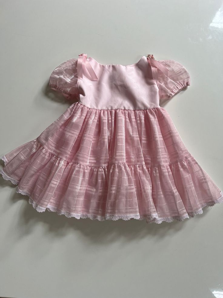 A gorgeous puffy pink pageant dress for toddler girl 4T. Vintage pageant dress with a sheer overlay and puff sleeves in pink. By Faye's Fantasies, tagged 4T, seems accurate. Buttons back of neck. Has belt loops, but lissing belt. I would add pink satin ribbon. Great condition except a little stain on back of neck where button closure is- I have not tried to treat. Measures 19 inches long and 11 inches across pit to pit. Pink Tiered Princess Dress For Spring, Tiered Pink Princess Dress For Spring, Pink Ruffled Princess Dress For Baptism, Sweet Pink Princess Dress With Ruffles, Pink Ruffled Party Petticoat, Sweet Fitted Ruffle Tutu Dress, Sweet Ruffled Fitted Tutu Dress, Pink Short Sleeve Tutu Dress With Ruffles, Cute Princess Dress With Puff Sleeves And Ruffles