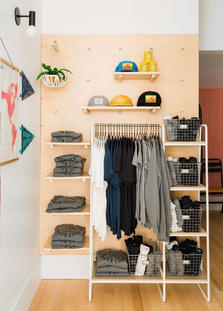 an organized closet with clothes, shoes and other items on the shelves in front of it