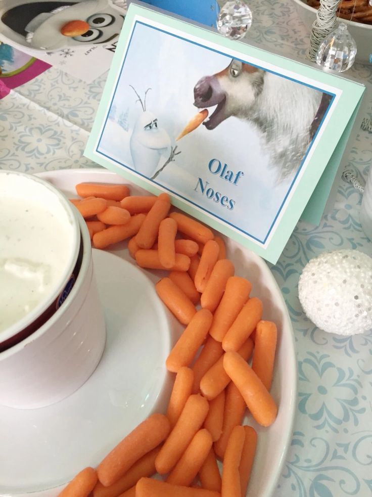 carrots on a plate next to a bowl of yogurt and a card