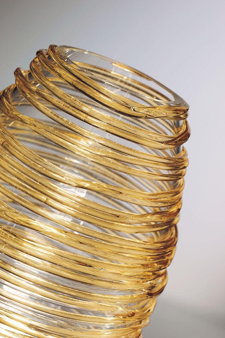 a stack of gold colored coils sitting on top of a white table next to each other