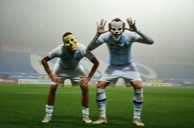 two soccer players with masks on their faces are standing in the middle of a field