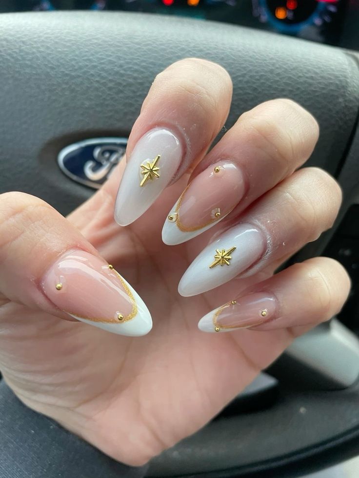 Fancy Oval Nails, Charmed Nails Acrylic, Classy White And Gold Nails, White Grad Nails Almond, Nails White Gold Design, Nail Designs With Gold Charms, Grad Nail Inspo Almond, Almond Nails For Graduation, White French Nails With Charms