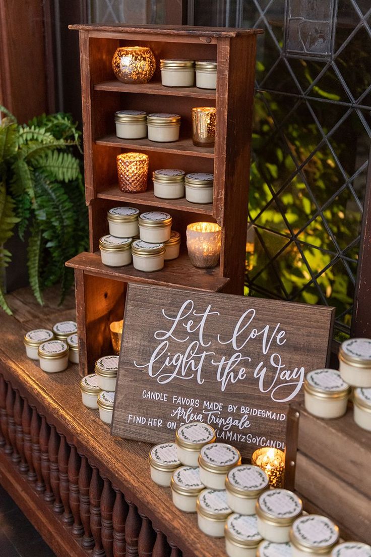 some candles are sitting on a table with a sign that says let love light the way