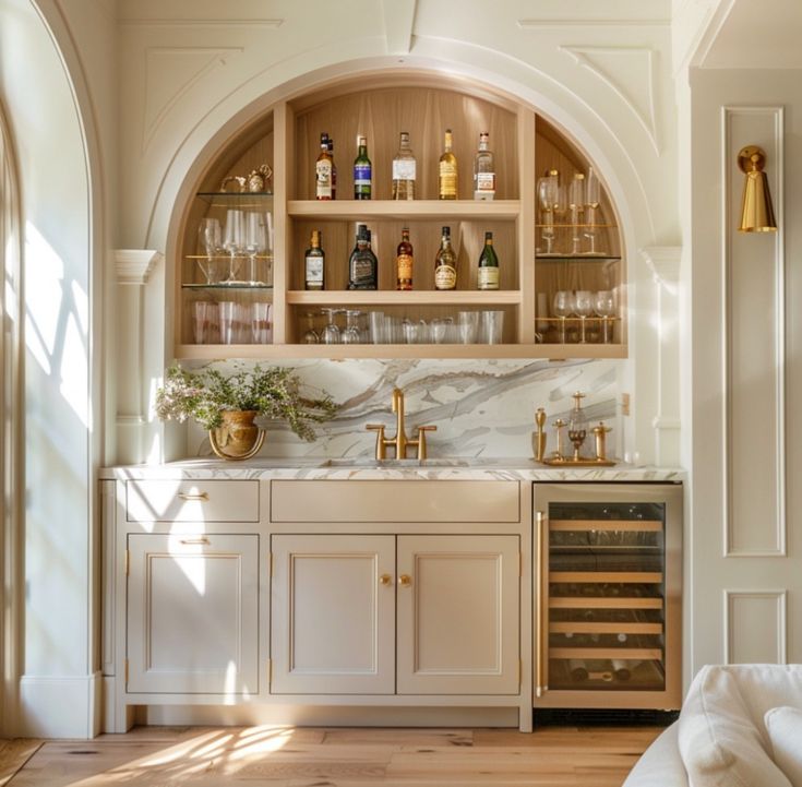 a kitchen with white cabinets and marble counter tops, an arched doorway leads into the dining room