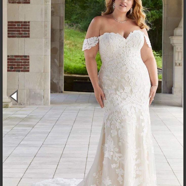 a woman in a white wedding dress posing for a photo with her hands on her hips