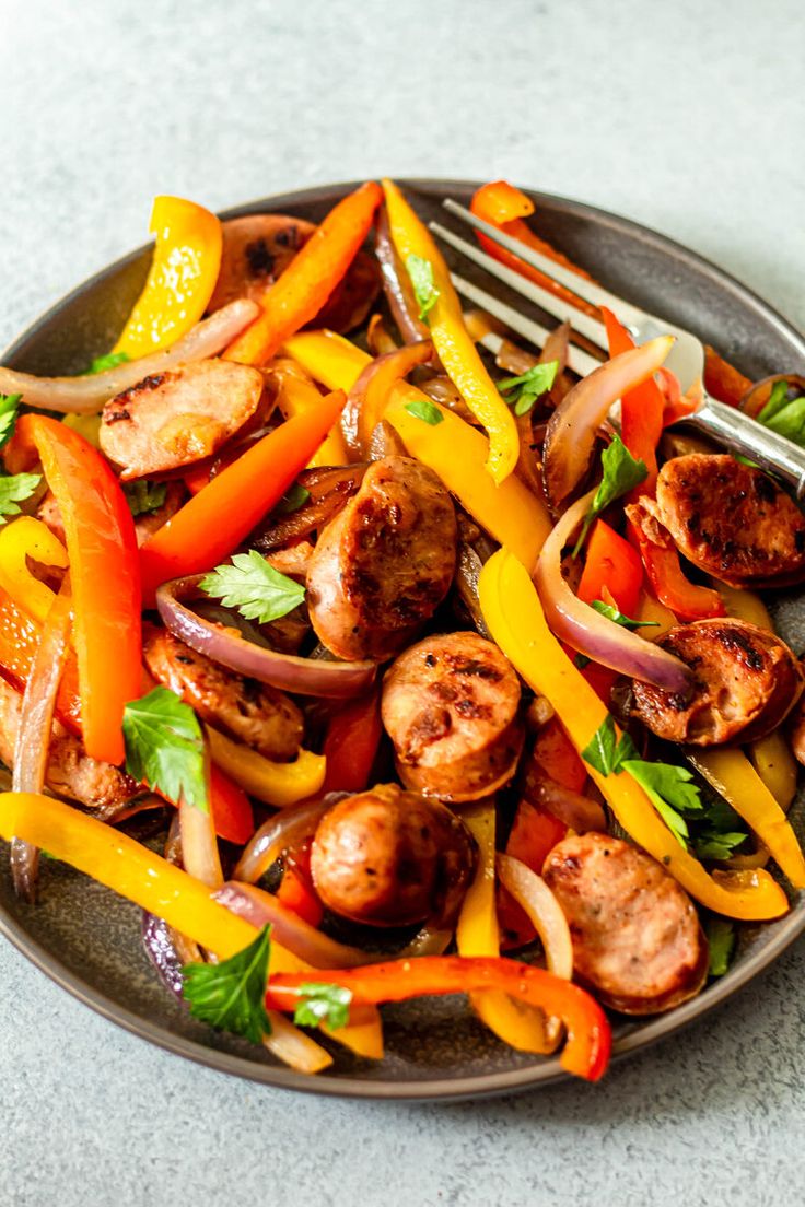 a plate filled with sausage, peppers and onions