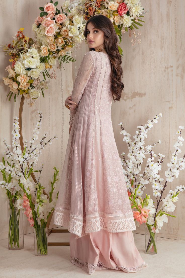 Make a strong style statement this Eid, with this long, flowy kalidar peshwas featuring delicate floral cut work embroidery further enhanced with beads, sequins and pearls. Hints of blue brings sudden oomph to the outfit. Paired with lace & fabric manipulated, hand embellished dupatta and paneled flared pant with lace details to complete the look. Shirt Fabric: Pure Embroidered Chiffon Shirt Length: 50” Pant Fabric: Khaadi Silk Dupatta Fabric: Pure Chiffon Shirt, Pant & Dupatta Color: Dusty Pink Eid Reception Dress With Chikankari Embroidery, Lace Dress For Diwali Reception, Lace Reception Dress For Diwali, Festive Lace Gown, Reception Georgette Churidar With Chikankari Embroidery, Floor-length Lace Work Dress For Diwali, Floor-length Lace Dress For Diwali, Anarkali Dress With Lace Work And Traditional Drape, Reception Chikankari Georgette Churidar