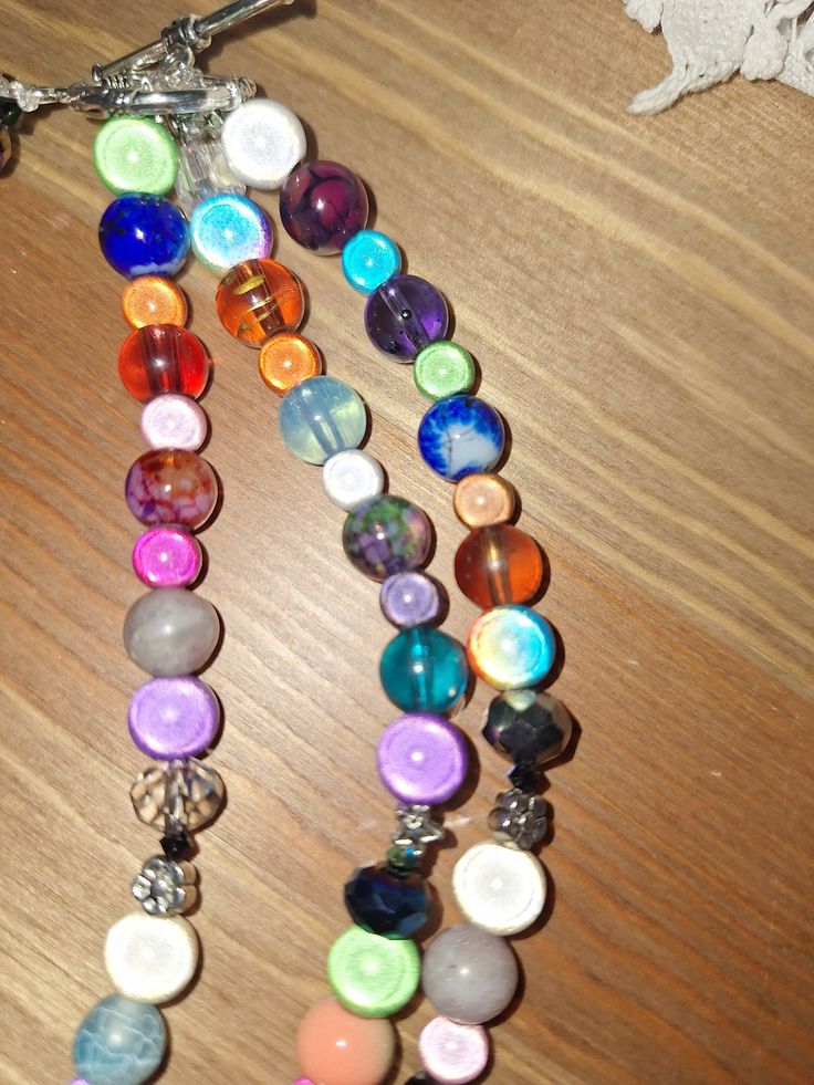 miracle bead necklace absolutely stunning 3 strands of stunning multicoloured round beads in a range of colours there are many different coloured glass beads some pretty silver toned flower spacer beads and a mix of brightly coloured acrylic beads with a pretty silver toned large toggle closure the length is 20 inches but has 2 further graduated strands It is a really statement necklace which will look stunning with many outfits it would make a stunning festival  necklace, please examine the pho Festival Necklace, Coloured Glass, Gorgeous Necklaces, Strand Necklace, Acrylic Beads, Necklace Handmade, Metal Beads, Bead Necklace, Spacer Beads