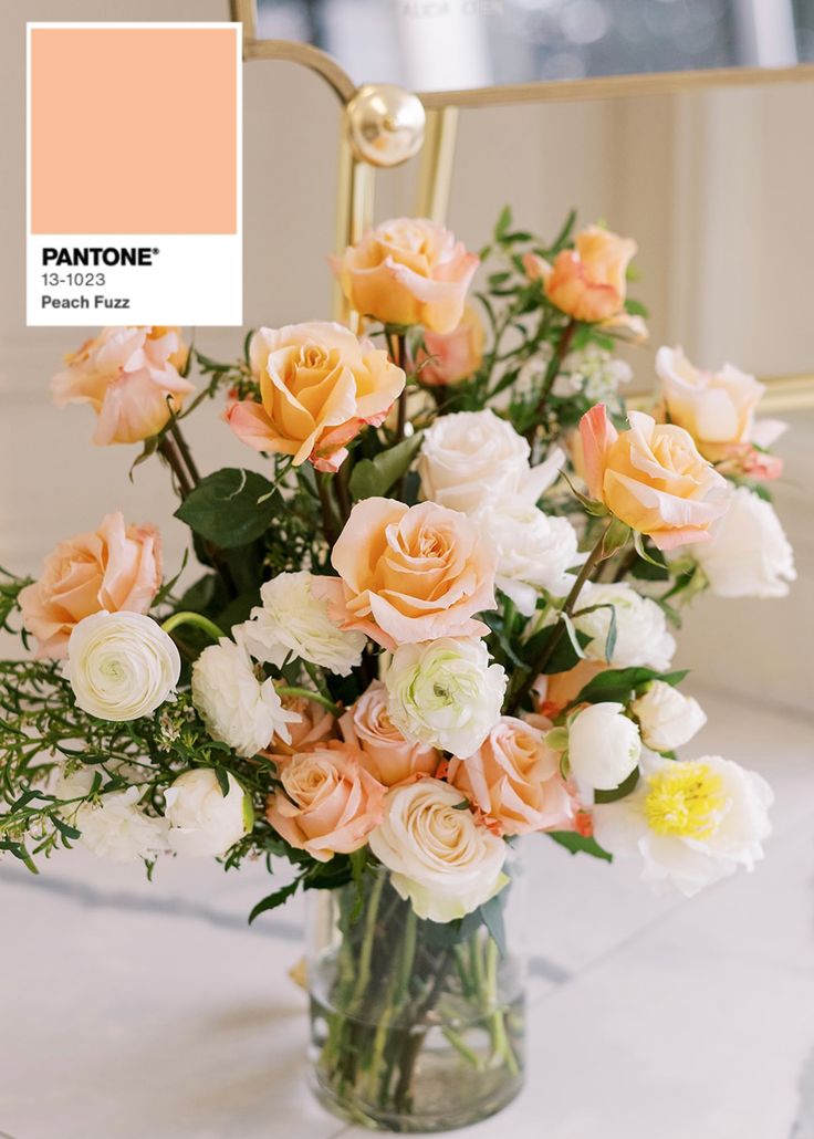 a vase filled with lots of flowers on top of a white marble table next to a mirror