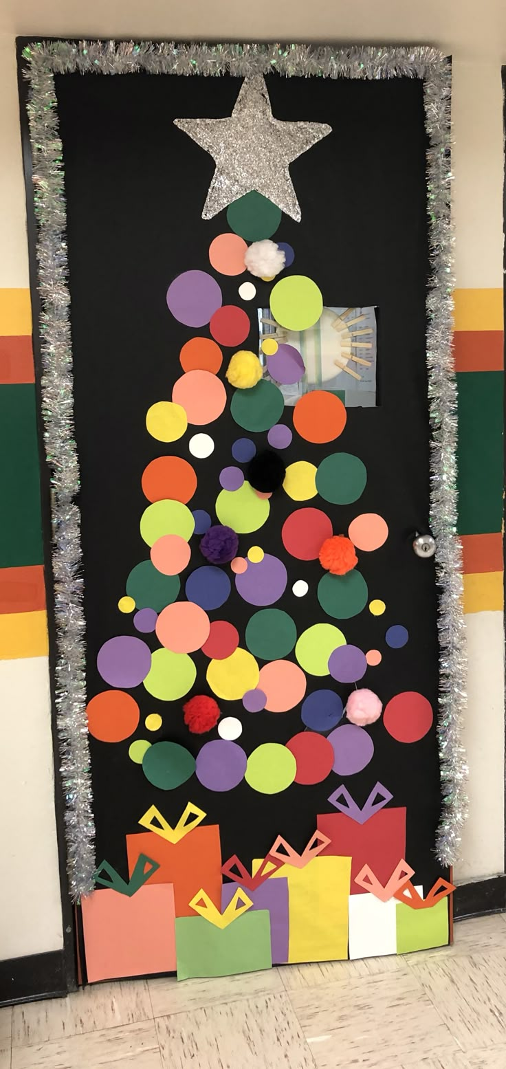 a christmas tree made out of different colored paper bags and presents on the floor in front of a door