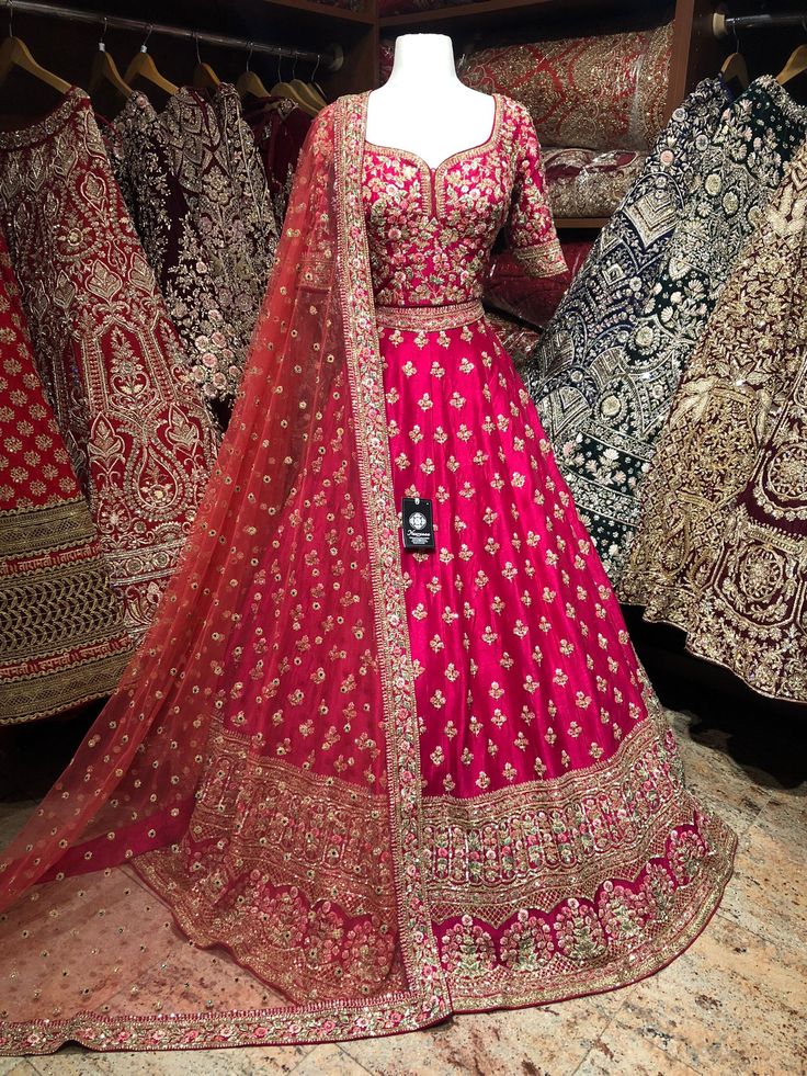 Ruby red hand embroidered on raw pure silk in a combination of zardozi, resham ,sequins and multi-color thread embroidery with stonework embellishment lehenga teamed with similarly embroidered blouse and includes net dupatta. Celebrate your luxurious moment in this fully designer silk lehenga. Fabric: Raw Silk Size: 38/M Occasion: Wedding Ceremony or Reception WASH CARE INSTRUCTIONS - Please Dry clean only when it is applicable. Slight color variation is possible due to digital photography. Read Embroidered Kundan Floor-length Gown, Embroidered Dola Silk Gown For Festivals, Festival Embroidered Dola Silk Gown, Pink Embroidered Fabric With Dabka Work For Reception, Embroidered Pink Fabric With Dabka Work For Reception, Embroidered Chinon Gown For Festivals, Festive Kundan Gown With Embroidery, Festive Kundan Embroidered Gown, Festive Embroidered Kundan Gown