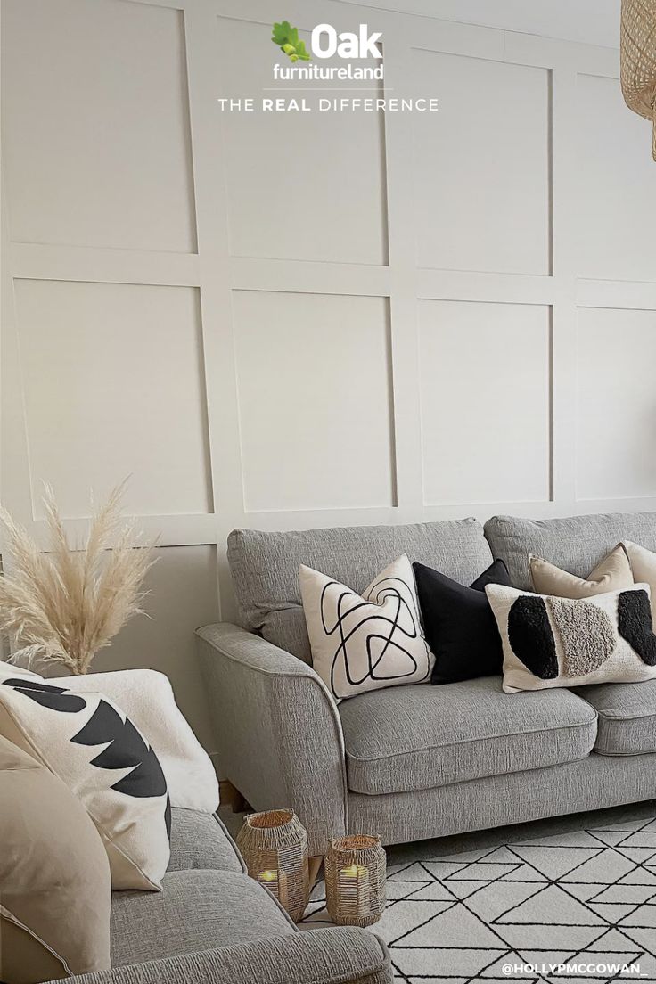 a living room with couches and pillows on the floor in front of a white wall