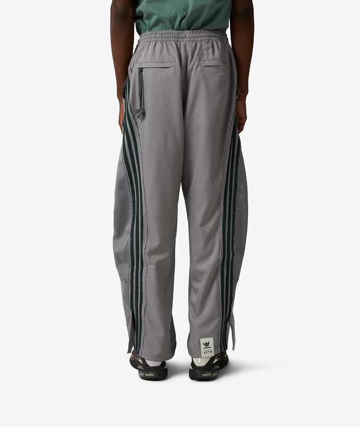 Founded in Germany in 1949, adidas has grown from a small sportswear company into a global powerhouse, renowned for its innovative designs and commitment to quality. The brand continually evolves, forever at the cutting edge of fashion and functionality. Get ready to elevate your wardrobe with the adidas Track Pants x Song for The Mute, a standout piece in the Fall/Winter 2024 collection. These designer collaboration sweatpants in a sophisticated gray hue merge classic comfort with avant-garde s Adidas Track Jacket, Adidas Track Pants, Running Short, Adidas Track, Fall Winter 2024, Avant Garde Fashion, Adidas Running, Running Leggings, Bank Card