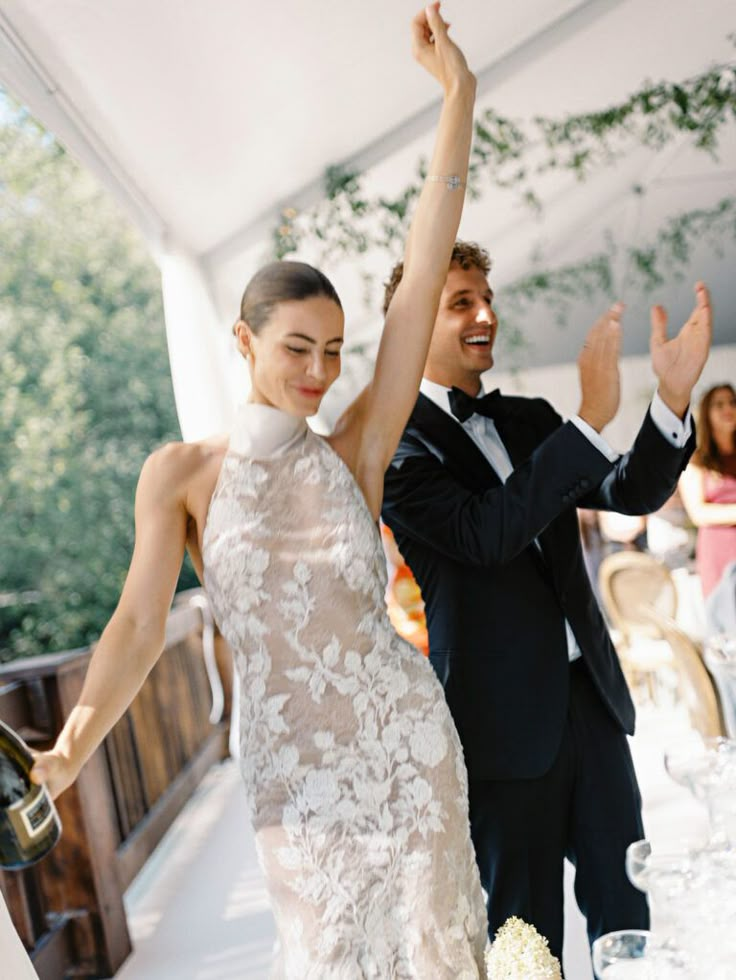 a bride and groom dancing at their wedding reception in a tented area with white linens