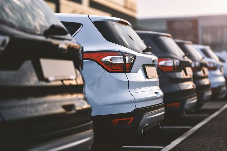 a row of parked cars sitting next to each other