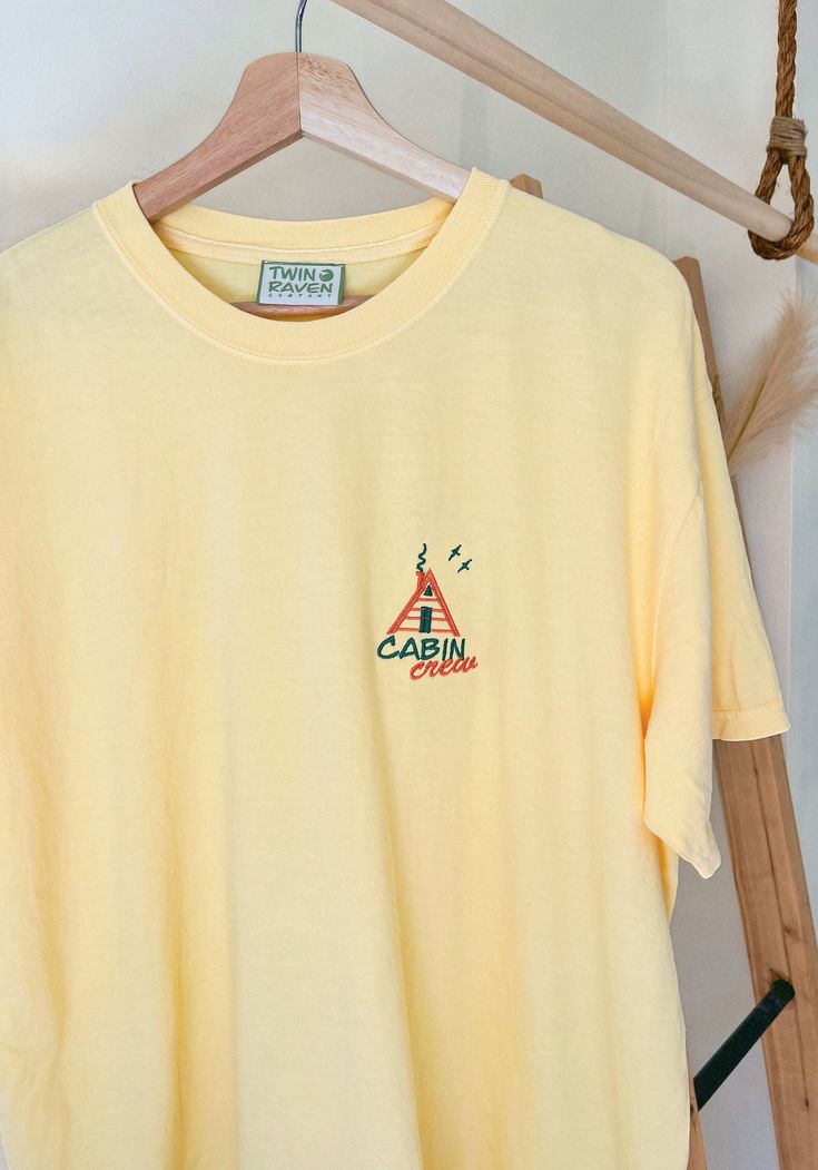 We sell primarily on our website and offer free shipping options + hats. TwinRavenCo Prepare for a summer full of adventures in our comfy retro cabin crew tee. 𓄿 Garment Dyed- giving that perfect vintage look that will remain for the life of the T-shirt 𓄿 Relaxed fit 𓄿 Topstitched, classic width, rib collar 𓄿 Twill taped neck and shoulders 𓄿 Pre-Shrunk 𓄿 Unisex Sizing.  Embroidery stabilizer is applied to the back of every professionally embroidered item and is never to be removed. This is Summer Outdoor Cotton T-shirt, Screen Print T-shirt For Summer Outdoor, Summer Adventure T-shirt With Short Sleeves, Outdoor Summer T-shirt With Screen Print, Summer Outdoor Screen Print T-shirt, Summer Adventure Short Sleeve T-shirt, Relaxed Fit T-shirt For Summer Adventure, Summer Graphic Tee For Camping, Summer Camping Graphic Tee