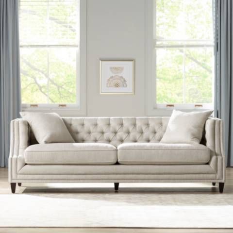 a white couch sitting in front of two windows