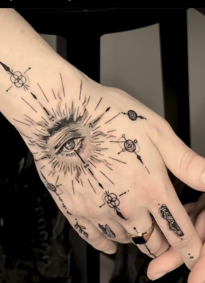 a person's hand with an all seeing tattoo on it