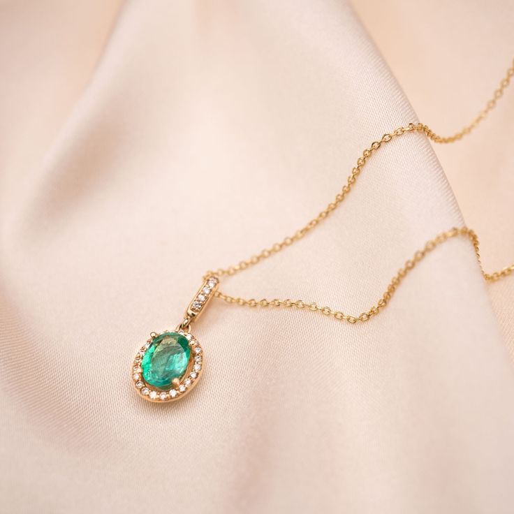 Take their breath away with our new 14k Emerald Oval necklace. 14k Solid Gold, Genuine Diamonds and Genuine Emerald 1 CTW Oval Emerald 28 Diamonds for a .18 CTW Available as a pendant only or with our 14k Cable Chain or 14k Box Chain in lengths 16" and 18" Made to order. Please allow 1 - 3 weeks for processing. Elegant Emerald Necklace With Cable Chain As Gift, Oval Cable Chain Jewelry Gift, Oval Cable Chain Jewelry As Gift, Gift Jewelry With Oval Cable Chain, Elegant Emerald Necklace With Cable Chain, Gold Necklace With Halo Setting And Oval Pendant, Oval Pendant Halo Jewelry For Gift, Luxury Oval Emerald Necklace Gift, Halo Oval Pendant Jewelry As Gift