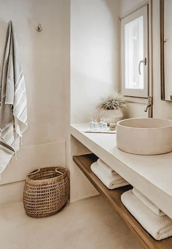 a bathroom with a sink, mirror and towels on the rack in front of it