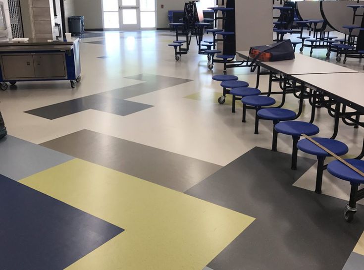 an empty cafeteria with blue benches and tables