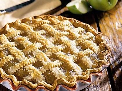 an apple pie sitting on top of a wooden table