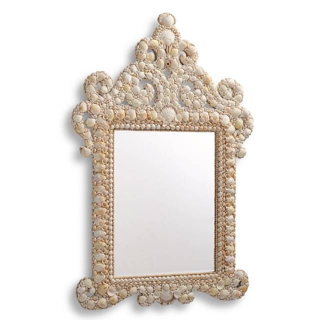 a mirror with shells on it and a white border around the frame, hanging on a wall