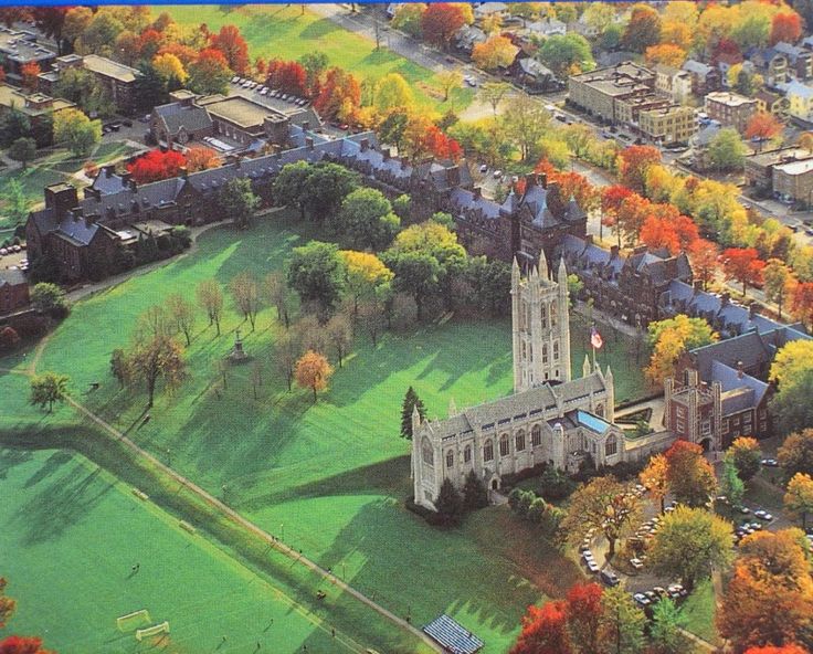 an aerial view of a large church surrounded by trees and buildings in the fall colors