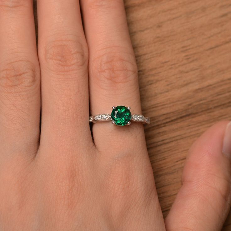 It is a lab emerald ring. The main stone is 7mm*7mm round cut, weight about 1.29 carats. The basic metal is sterling silver and plated with rhodium. To change the metal to a solid gold (white/rose) or platinum is also available, please ask for a quotation if you want. You can also go to my shop Home for more elegant rings: https://www.etsy.com/shop/godjewelry?ref=hdr_shop_menu Emerald is May birthstone. More emerald rings: https://www.etsy.com/shop/godjewelry?ref=hdr_shop_menu&section_id=207 Emerald Ring With Brilliant Cut For Promise, Emerald Promise Ring With Brilliant Cut, Emerald Ring With Prong Setting In Round Cut, Emerald Solitaire Promise Ring, Emerald Rings With Prong Setting And Round Cut, Emerald Ring With Prong Setting And Round Cut, Brilliant Cut Emerald Promise Ring, Green Sterling Silver Round Diamond Ring, Green Sterling Silver Diamond Ring