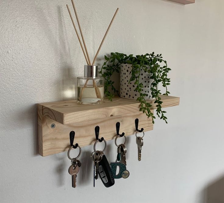 a wooden shelf with keys and plants on it