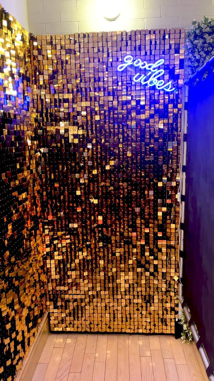 an elevator with gold and black tiles on the wall, next to a blue door