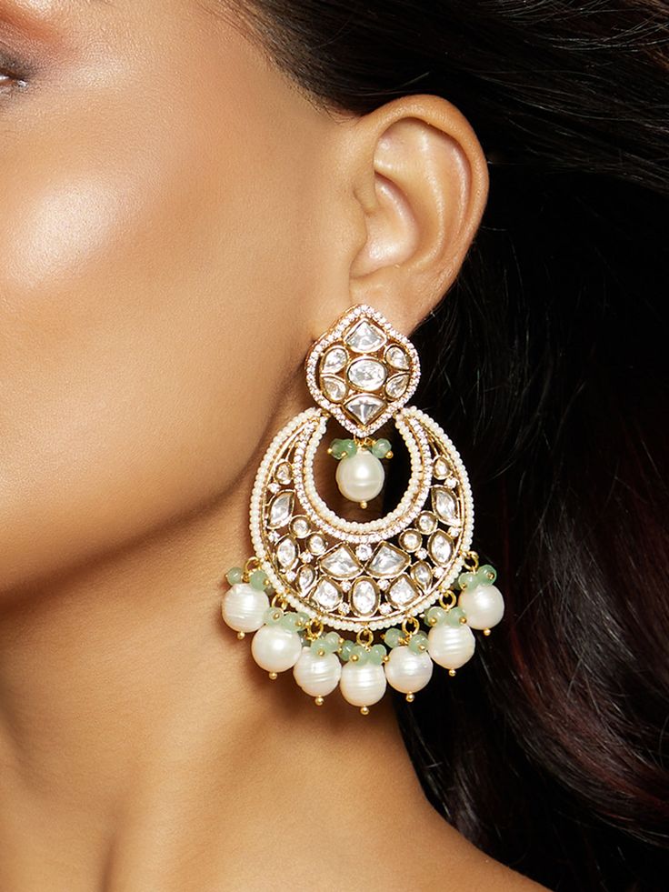 This designer chand baali earring is a handcrafted marvel, adorned with multi-shaped polkis, baroque pearls, and green agates. Perfect for festive occasions, weddings, and parties, it effortlessly enhances both Indian and fusion attire. Every piece is meticulously crafted with real semi-precious stones, imparting a regal look and feel to each artistic creation. Finish: 22KT Gold Plating Material: Brass, Polkis, Beads, Baroque Pearls Color: Gold, Green, White Size: One Size Closure Type: Push Loc Fusion Style Chandbali Pearl Earrings With Meenakari, Fusion Chandbali Pearl Drop Bridal Earrings, Fusion Chandbali Bridal Earrings With Pearl Drop, Fusion Style Chandbali Bridal Earrings With Pearl Drop, Fusion Chandbali Kundan Bridal Earrings, Fusion Style Kundan Chandbalis With Pearl Drop, Fusion Style Pearl Drop Chandbalis For Festivals, Fusion Style Pearl Drop Chandbalis For Celebrations, Festive Fusion Chandbali Pearl Earrings