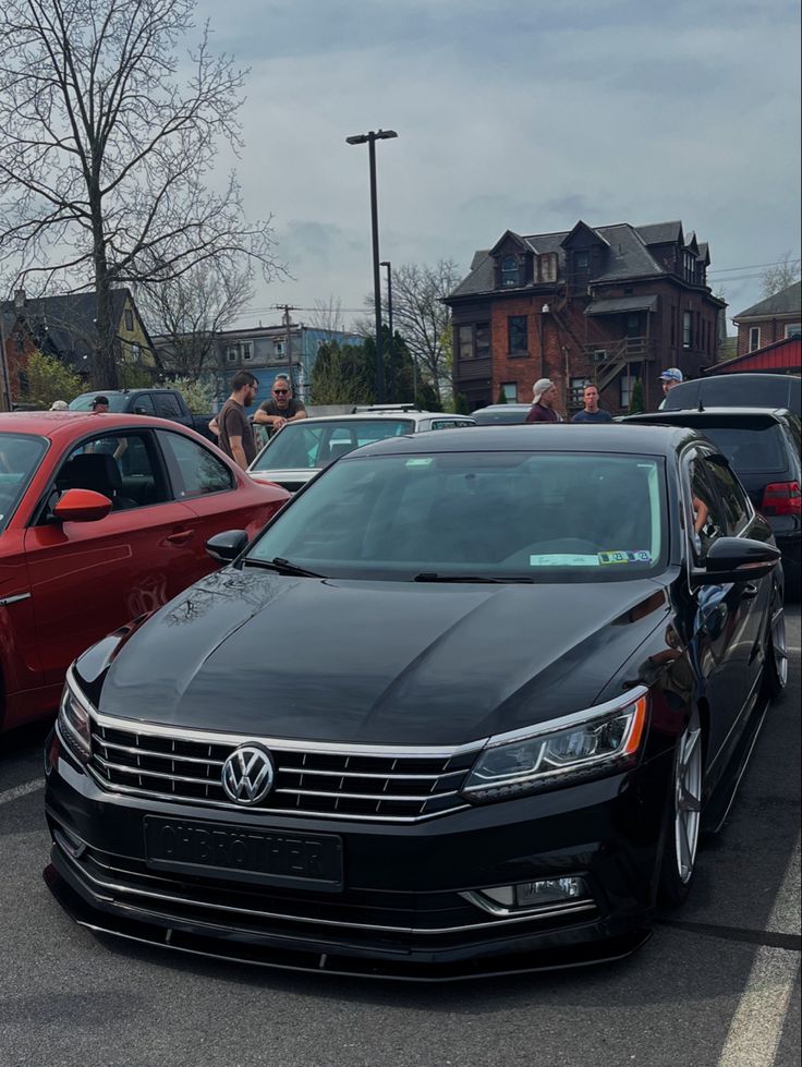 several cars parked in a parking lot with people looking at them